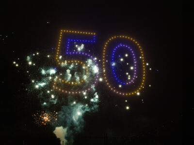 spectacle de drones logo d'entreprise 50 ans avec pyrotechnie