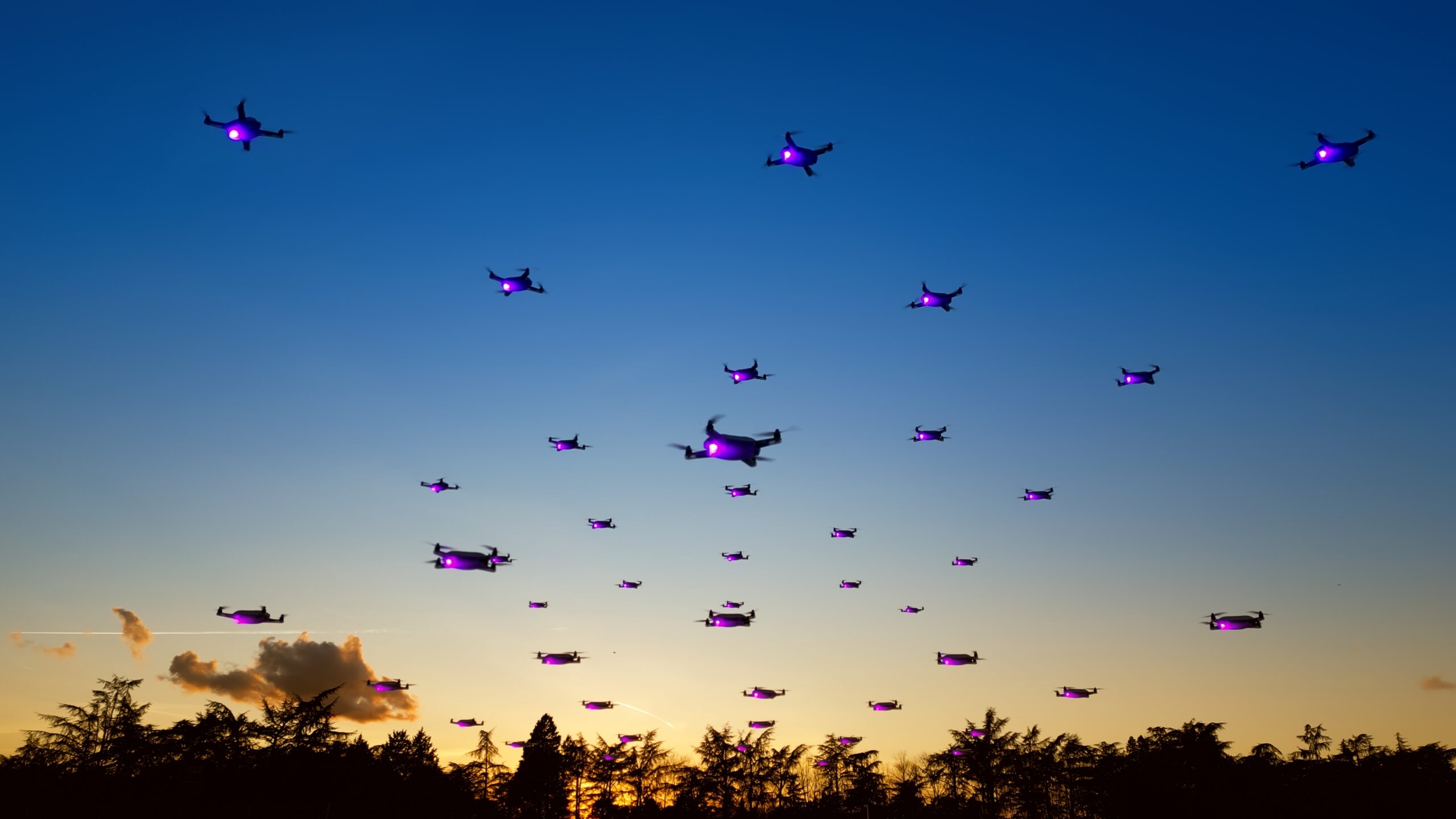 سرب من الطائرات بدون طيار الساطعة في السماء الزرقاء